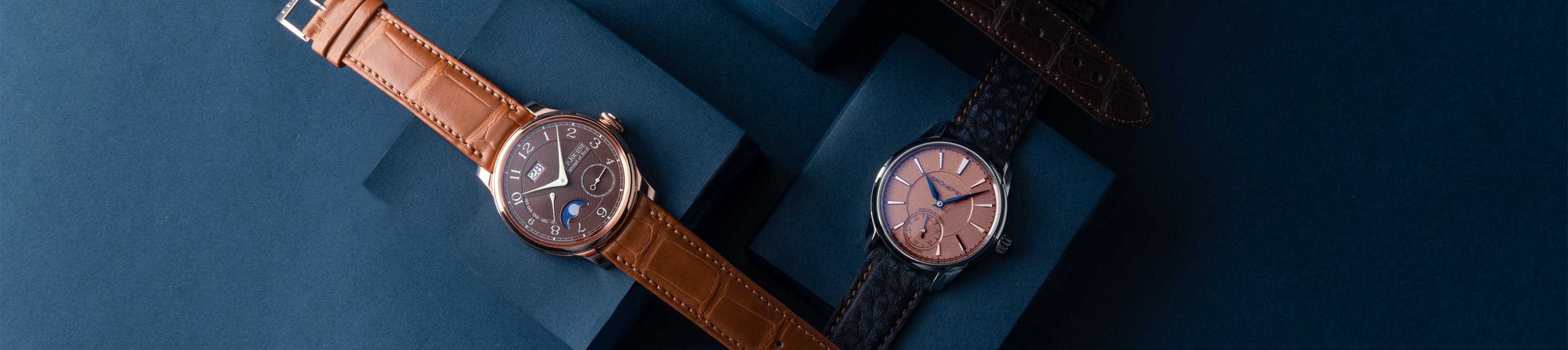 two watches on blue boxes