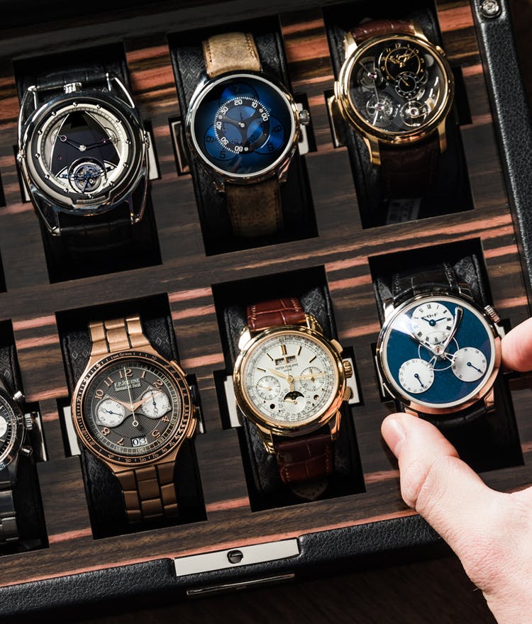person choosing watch from a box of watches